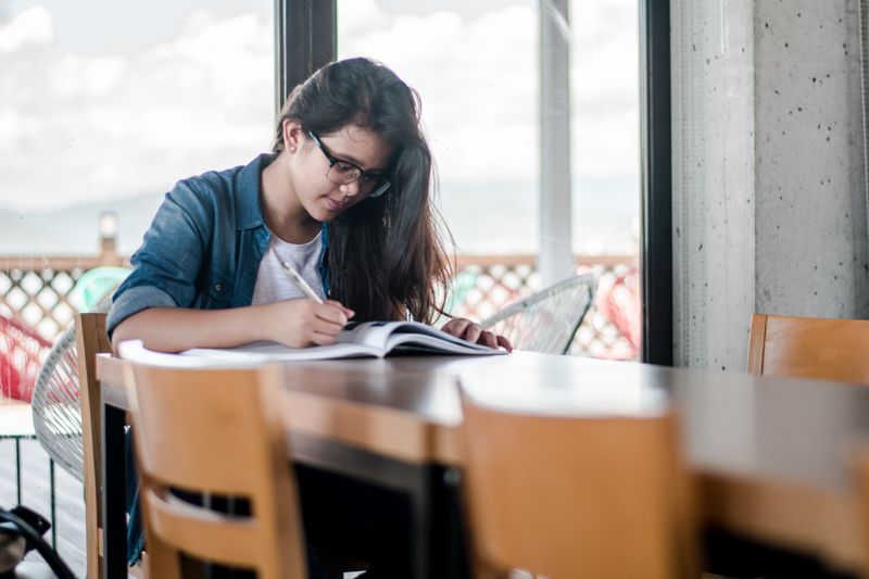 Young woman studying at a table.