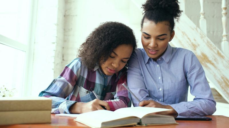 A mother and her child check homework together.