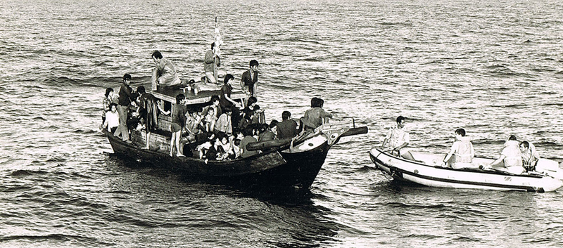 Vietnamese refugees on a boat in the ocean.