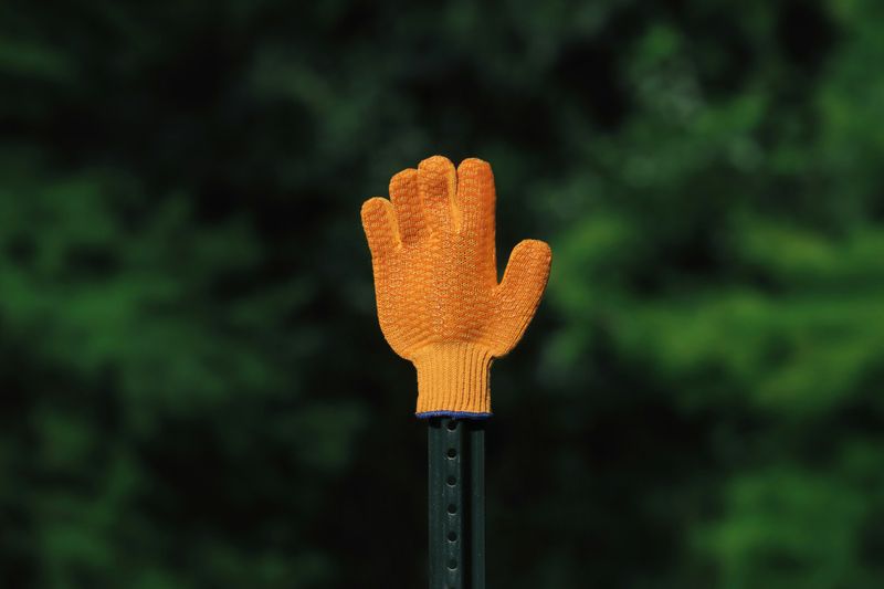 A yellow safety glove on a metal pole.