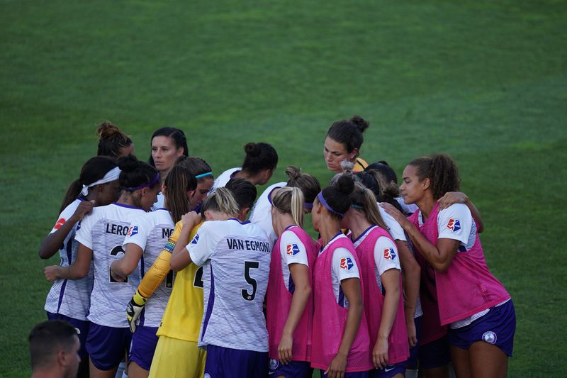 Women's football team in a huddle.