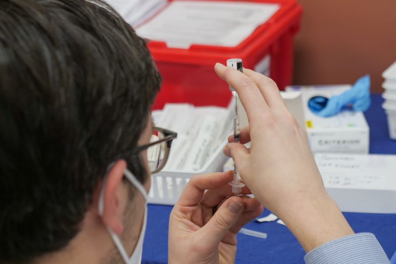 Pharmacist filling a needle syringe.