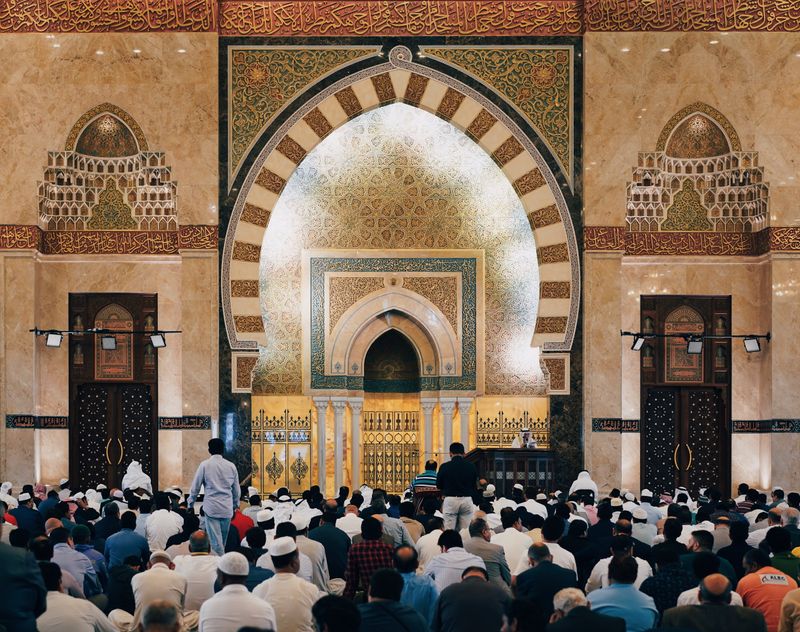 A group of people in a mosque praying.
