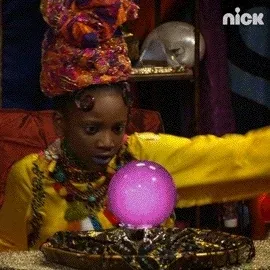 A fortune teller waves her hands around a crystal ball.
