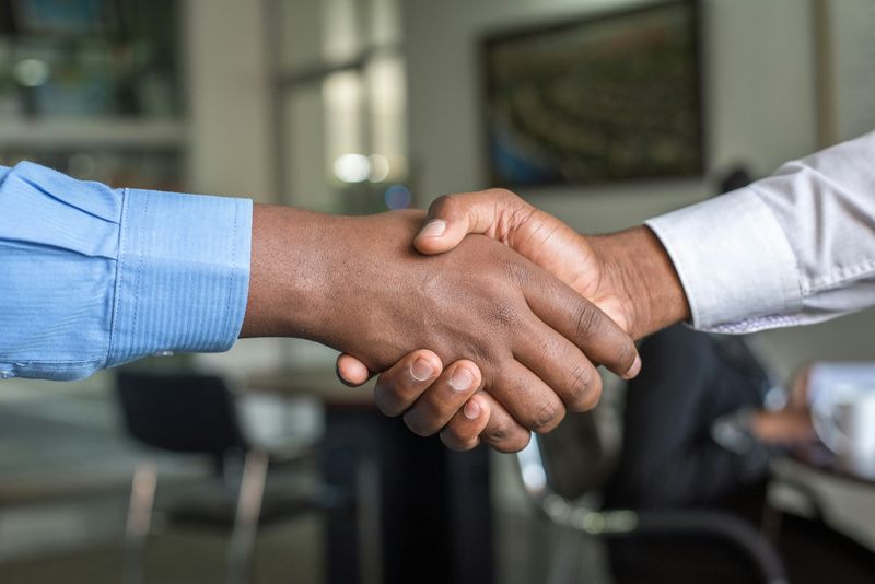 A pair of hands shaking in an office.
