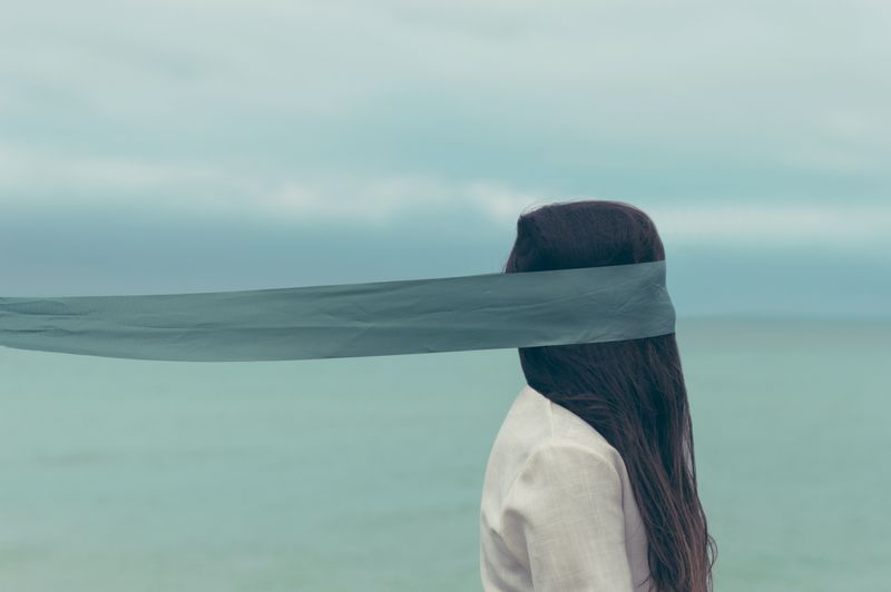 A woman with a veil being draped over her eyes