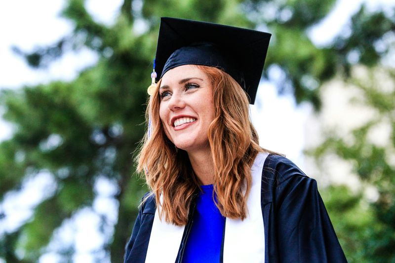 A smiling young woman wearing a cap and gown.