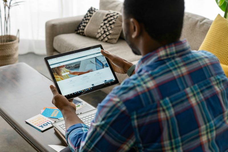 Man searching through LinkedIn website on his tablet. 