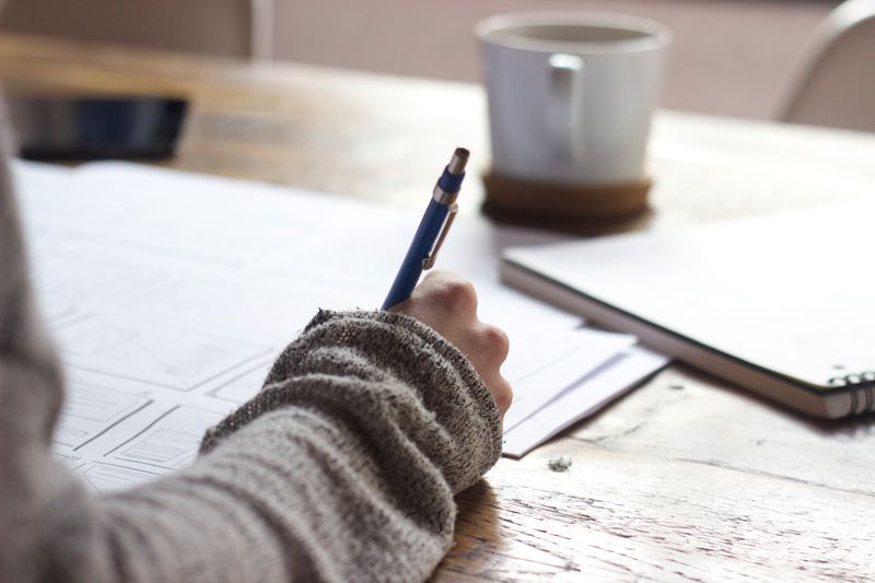 A person writing notes on a desk