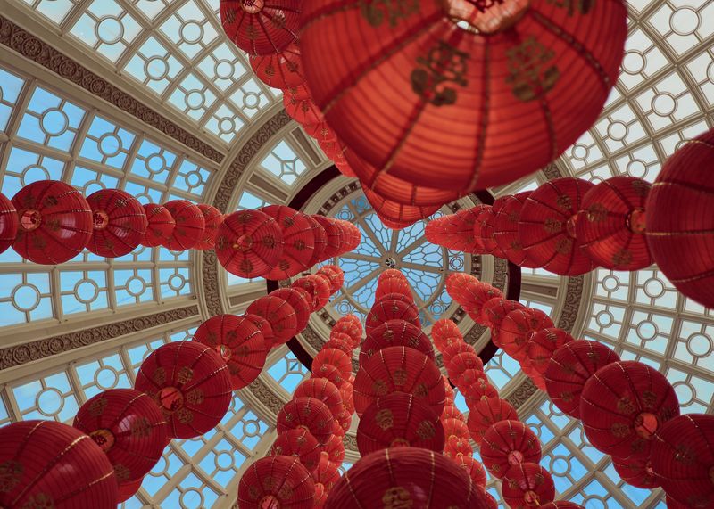 Rows of orange paper lanterns, seen from below, and cascading up into a geometric tower.