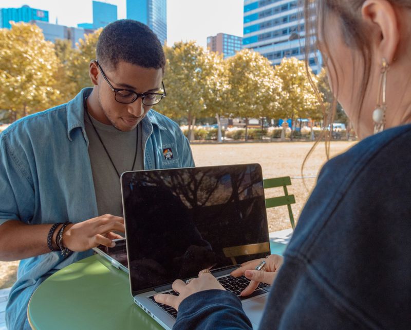 Two people studying together with a laptop and tablet. 