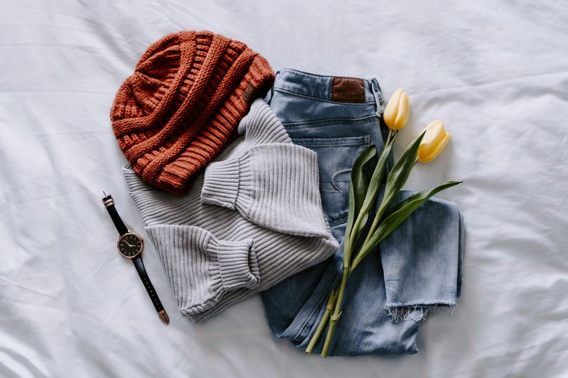 Second hand clothing on a white sheet, with a pair of tulips in the middle