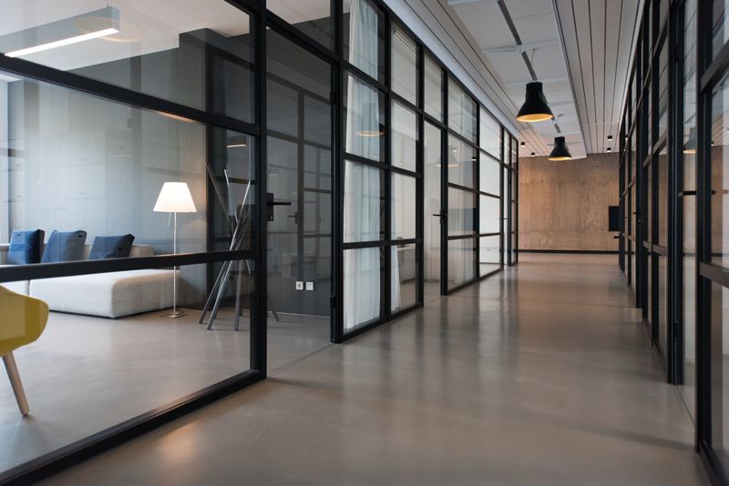 An office space with glass walls between each individual office.