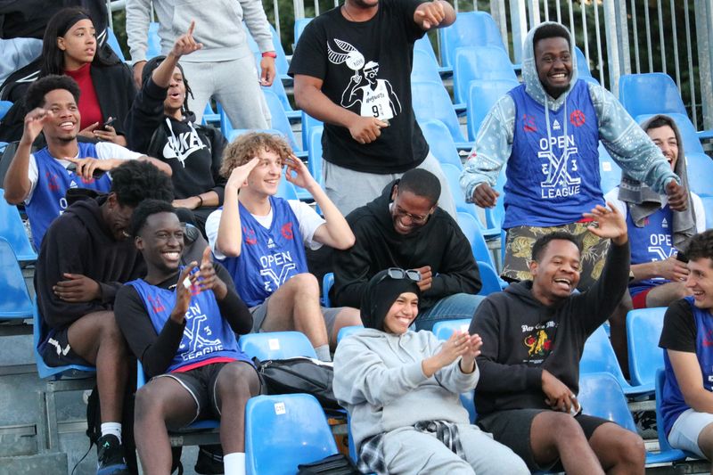 High school students cheering on their peers from the stands at a sporting game