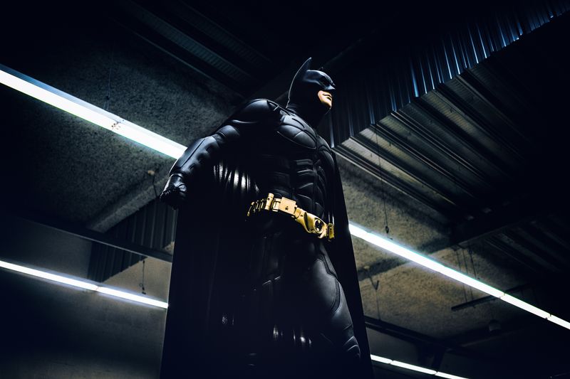Batman stands ready to fight in an underground room.