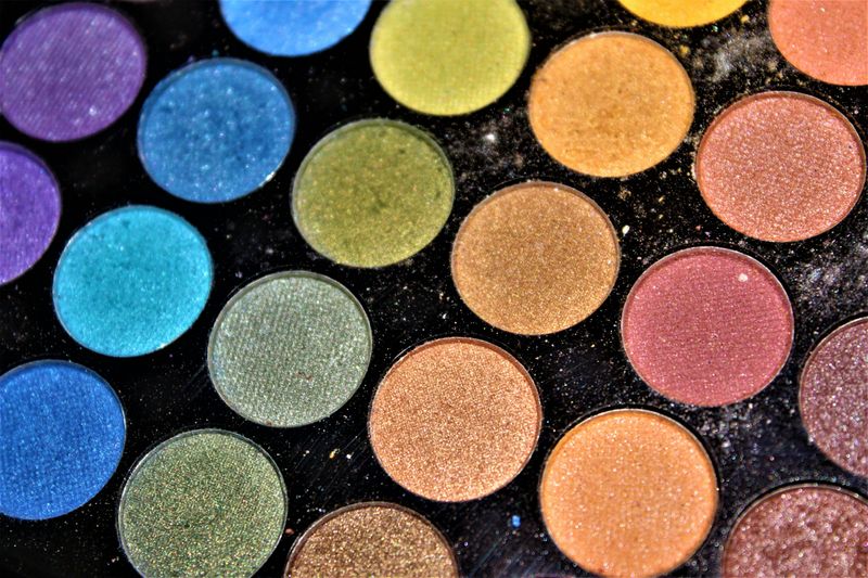 A close-up of an eyeshadow palette with a rainbow of colors. 