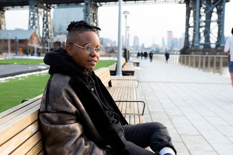 A person sitting on a public bench. They look deep in thought.