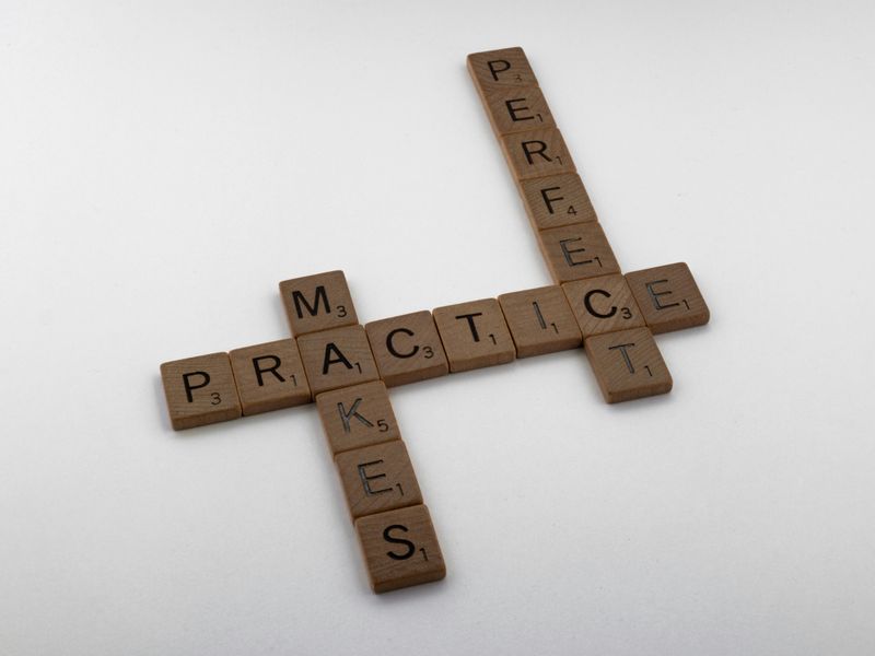 Wooden scrabble pieces spelling out practice makes perfect