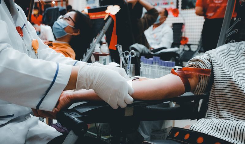 A phlebotomist taking blood from a patient's arm