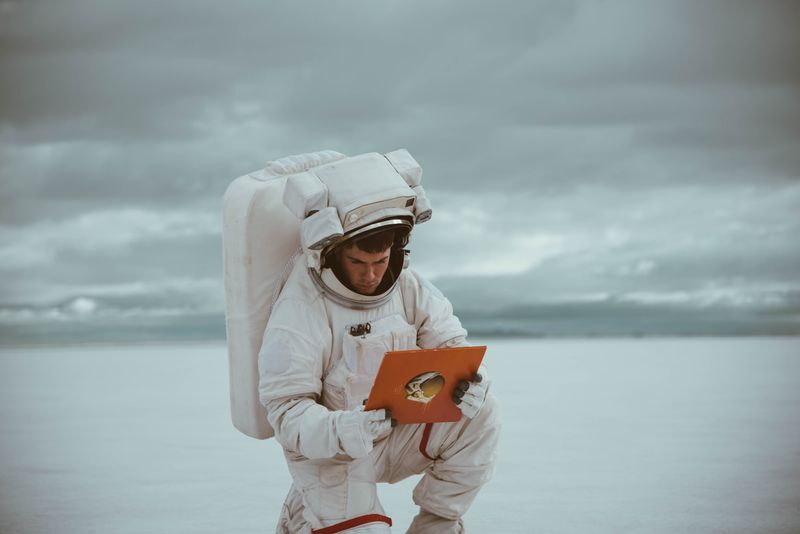 Astronaut in spacesuit holding electronic device