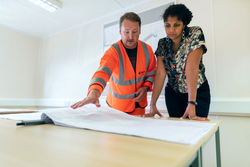 An engineer showing a planning document to a manager.