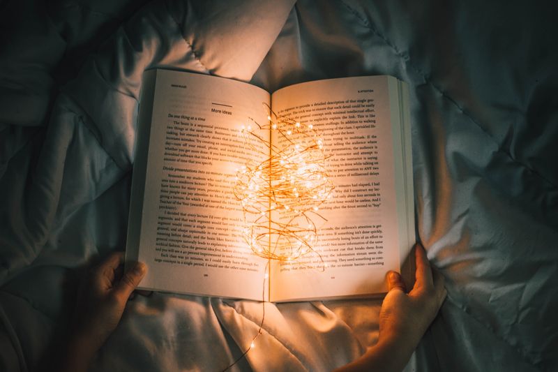 an open book with a string of lights running through it