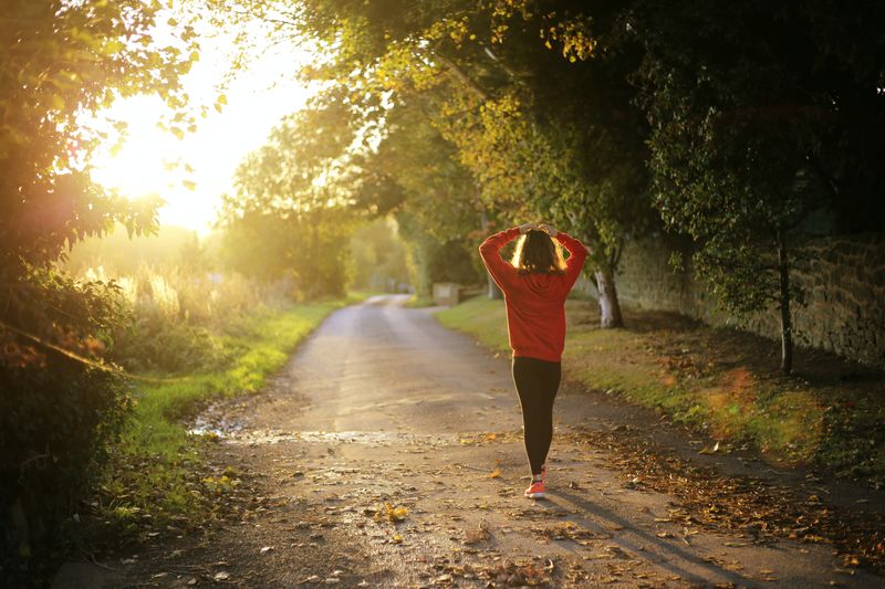 A woman going on a walk in the forest in the morning.