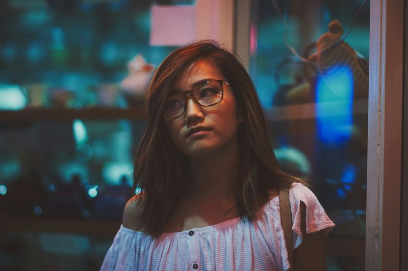 An Asian woman standing in front of a door.