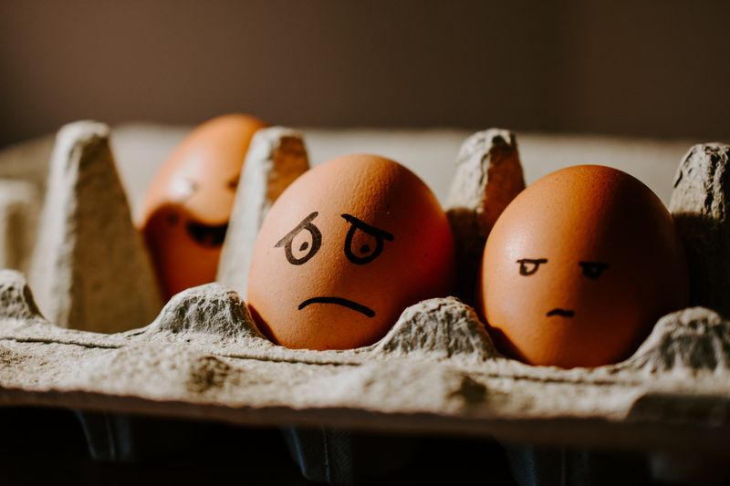 Photo of eggs with expressions of different emotions drawn on them.