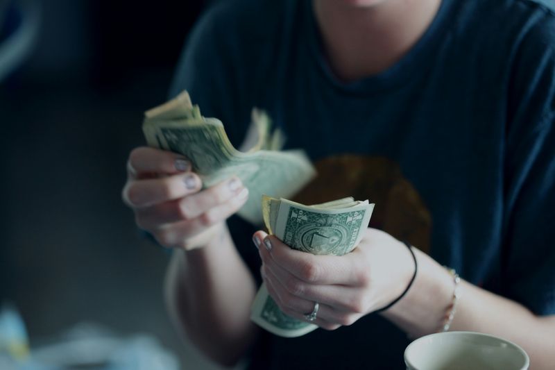 A person holding and counting bills.