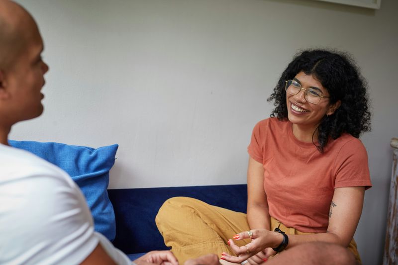 Two people smiling and talking to each other.