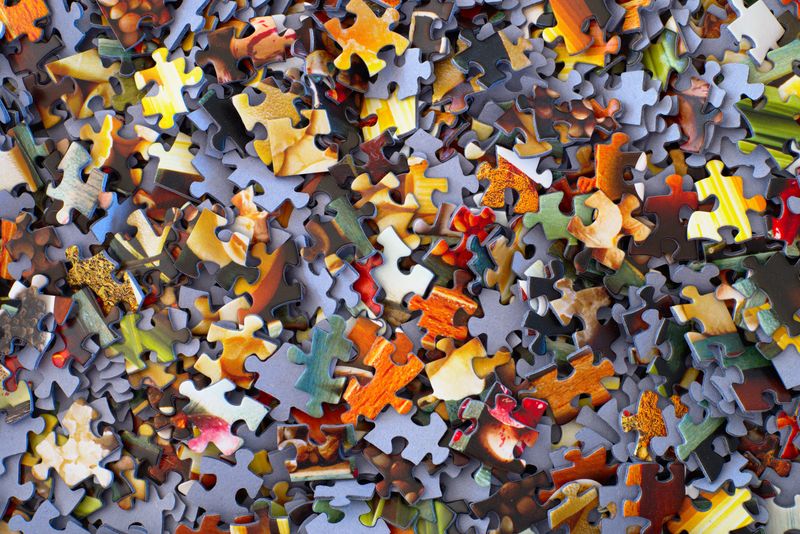 A number of puzzle pieces from a large puzzle in a pile.