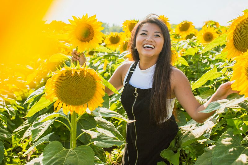 A happy person in a sunflower patch.