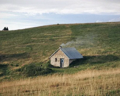 A small stone house on a hill.