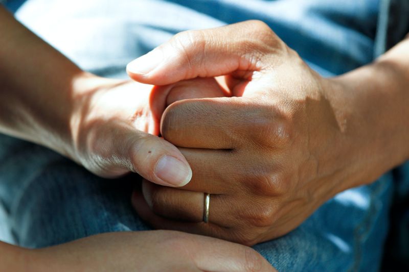 Two hands from different people holding for support.