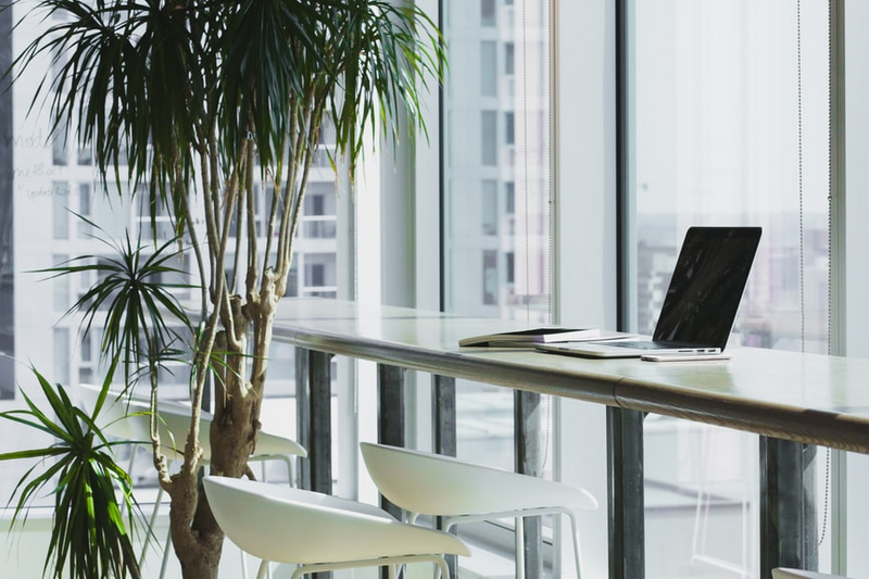 Computer on Desk in office with city view.