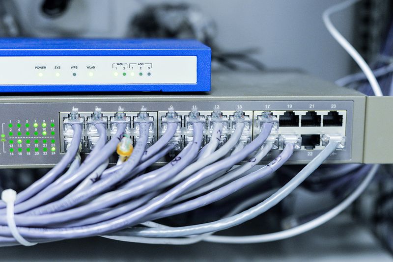 An image of  a network switch with many cables.