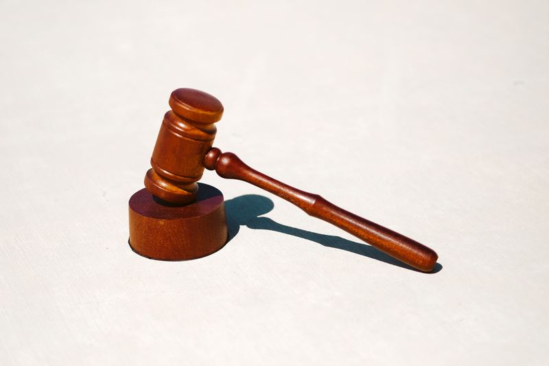 brown wooden judge gavel resting on a sound block of the same color