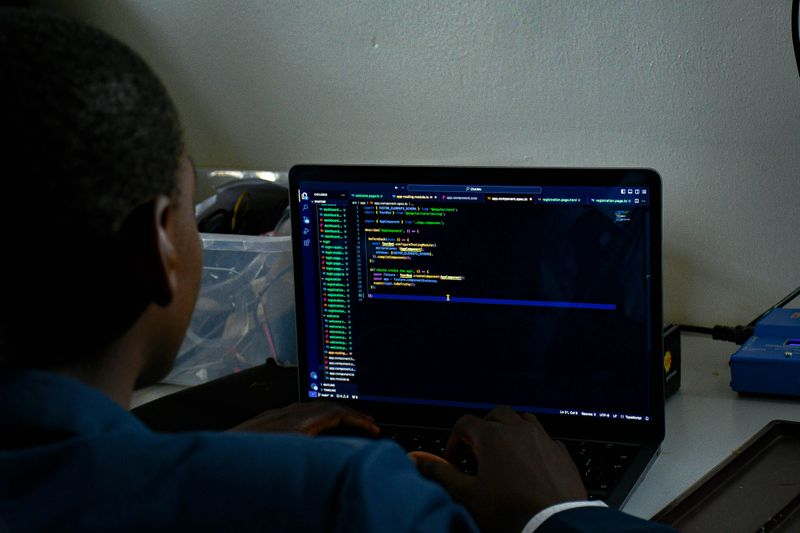 A person viewing lines of code in an editor on a laptop screen.