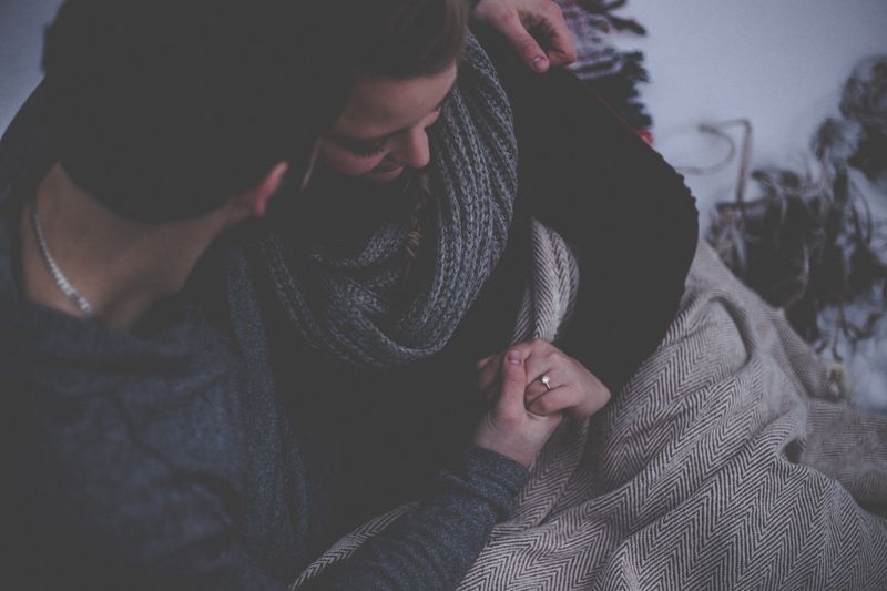 Couple holding hands and seemingly comforting each other