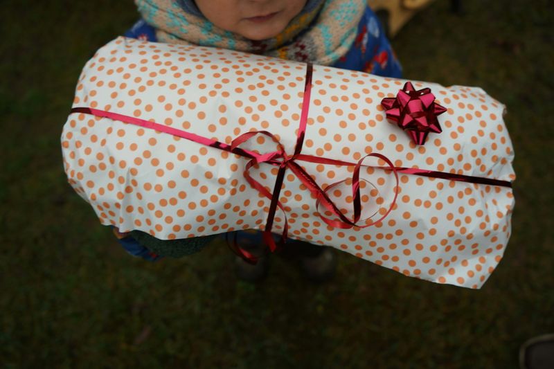 A child's gift wrapped in dotted paper and bound with a ribbon.