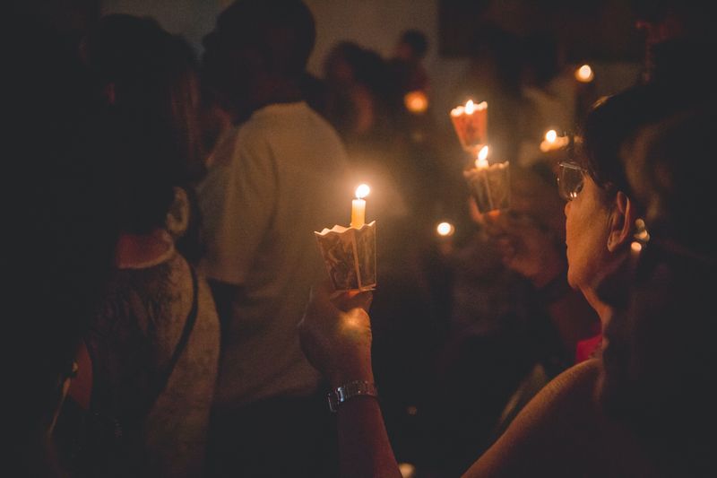 A group of people at a vigil holding candles
