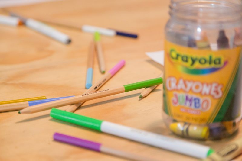 Markers, crayons, and pencils on a table.