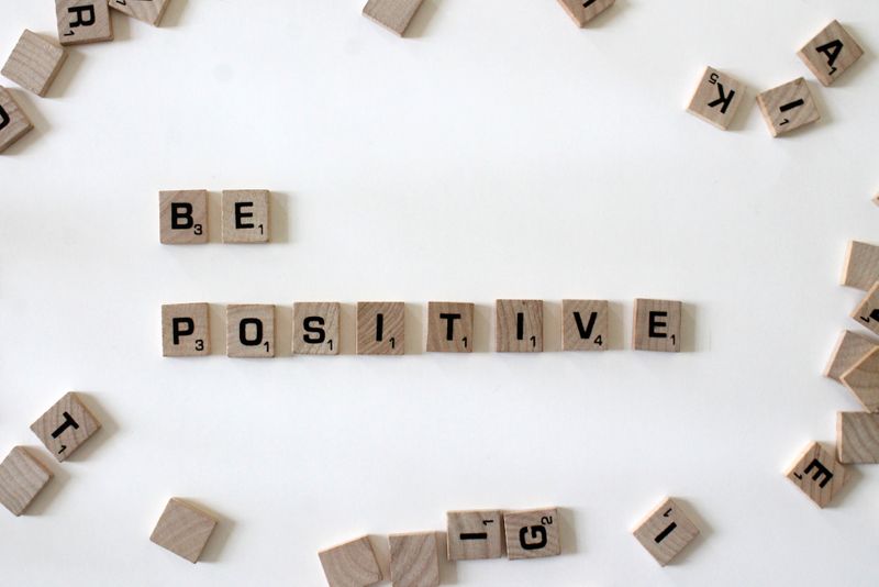 Scrabble blocks spelling 'Be positive'