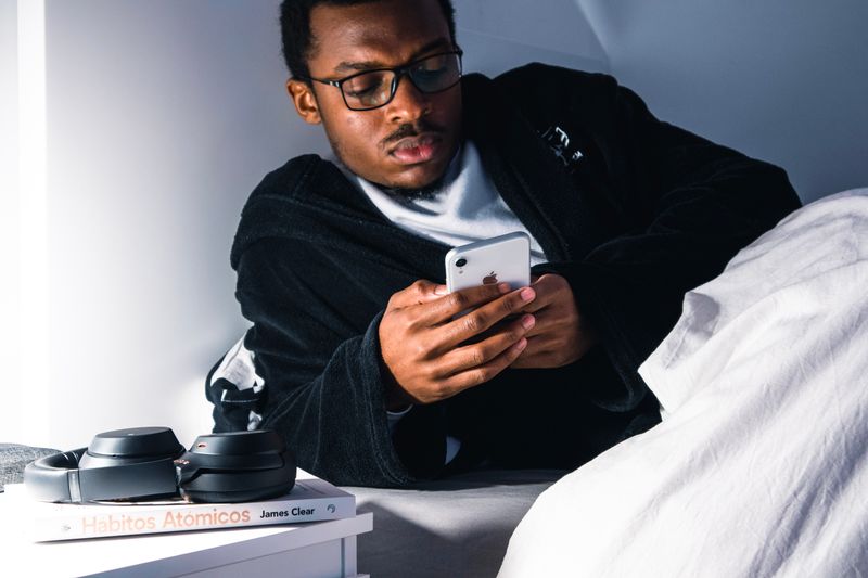 A young man looking at his phone before bed.