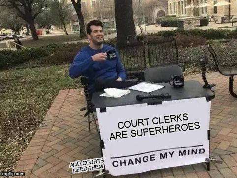 A man sitting behind a table with a sign that says: 