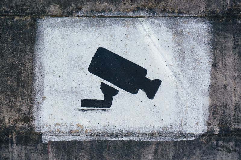 An image of a security camera painted on a wall.