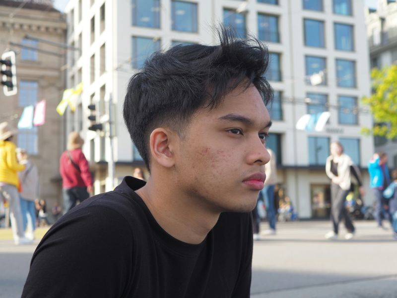A young man in deep thought in a public square.