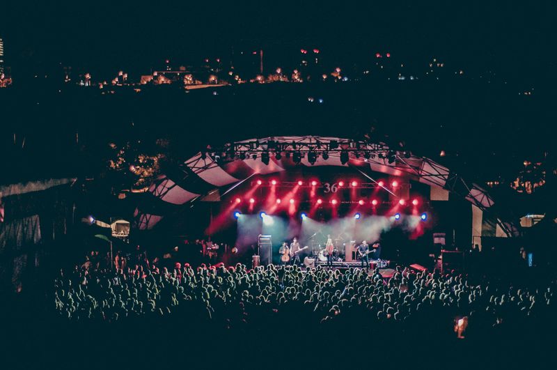 A vibrant concert scene capturing a large crowd of people gathered together.