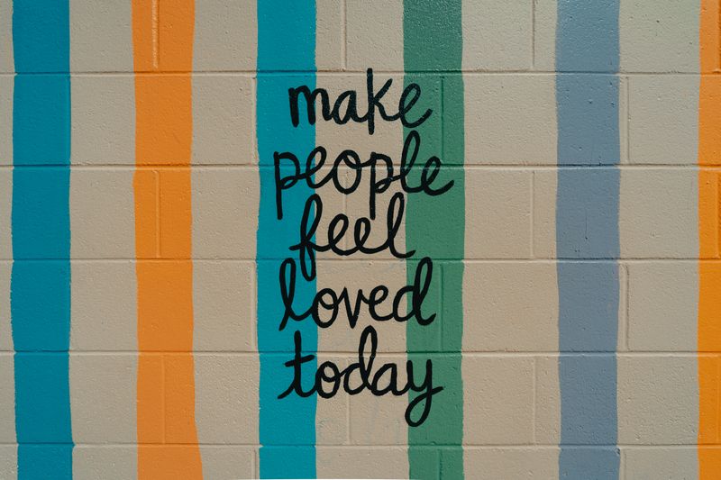 A mural that reads 'make people feel loved today'.